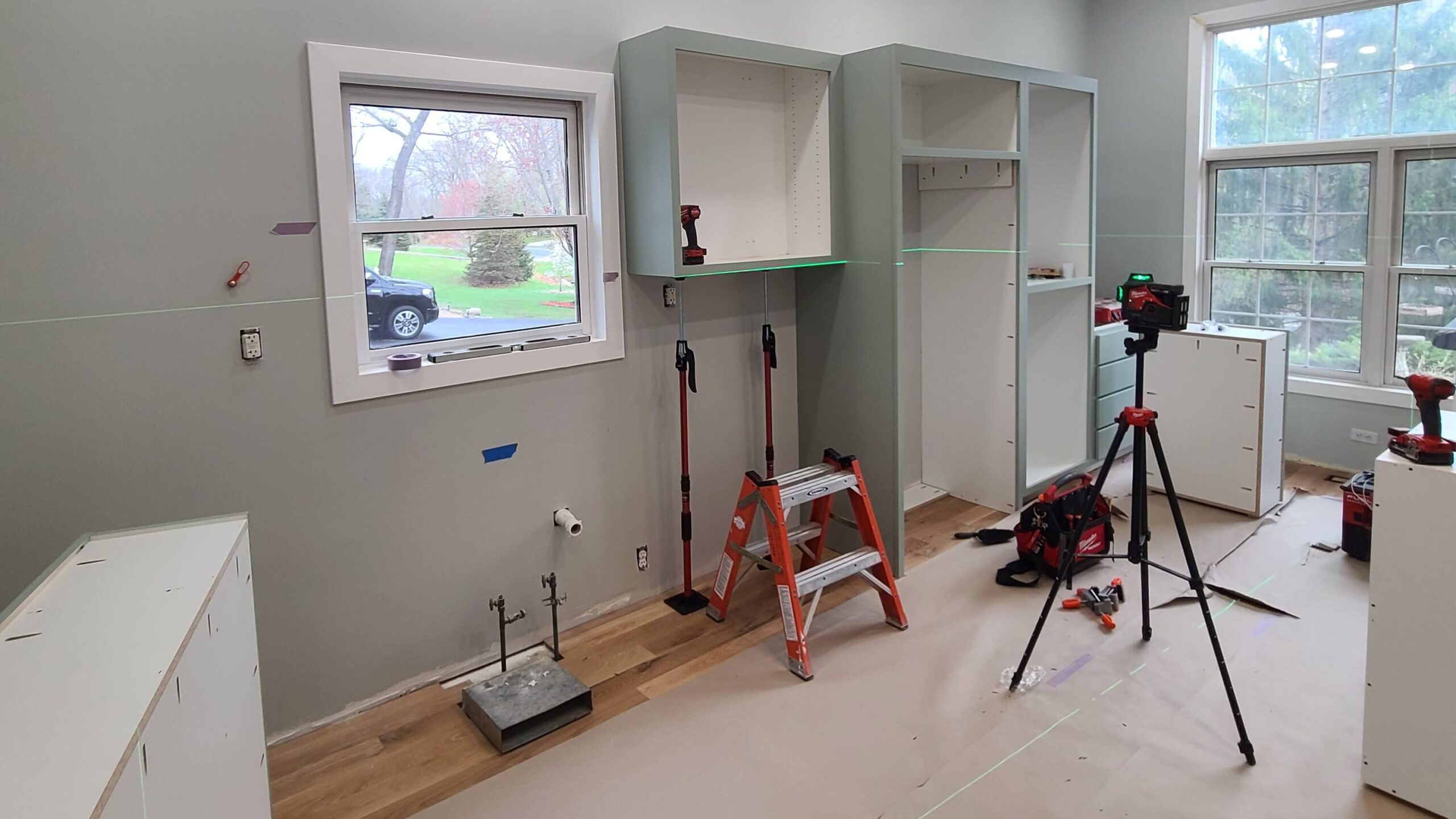 Twin Cities General Contractor installing new green cabinets at Forest Lake, MN home after interior damage