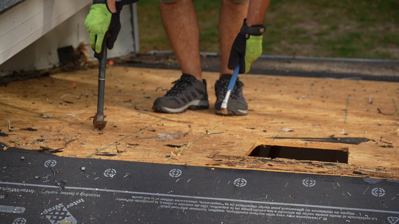 Roofer on a Marine on St. Croix, MN home removes old nails during roof installation prep
